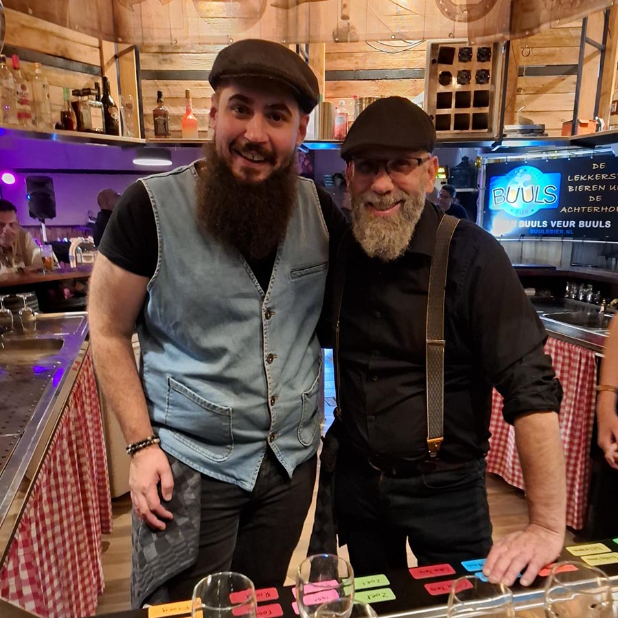 Twee mannen poseren bij een bar tijdens een evenement in Wehl